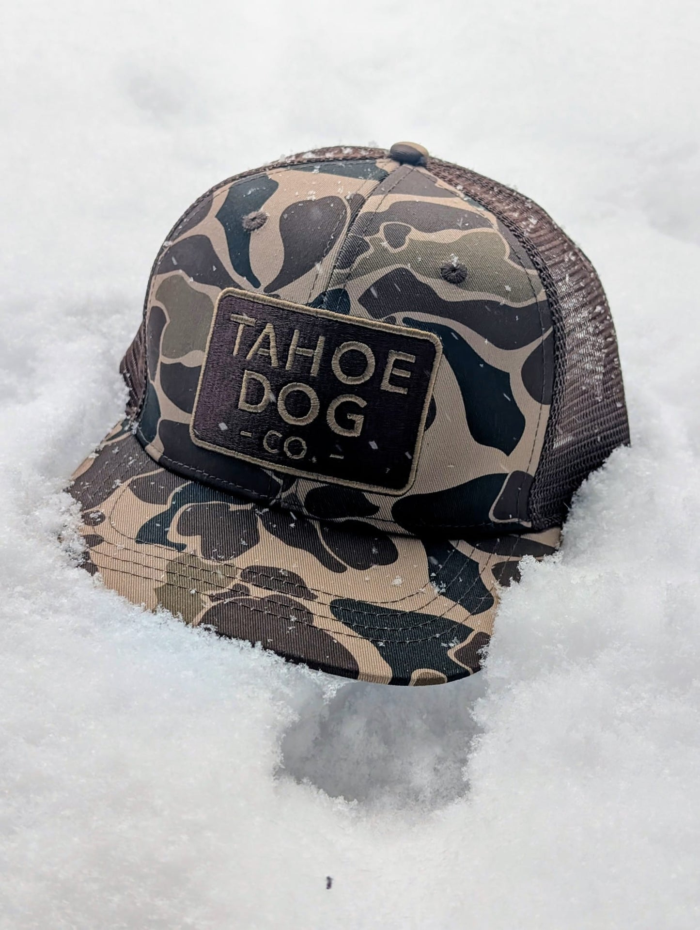 Camo trucker hat featuring Tahoe Dog Co. logo (aka "The Rex")