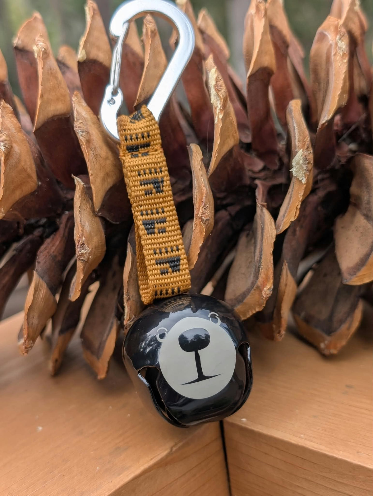 Tahoe Dog Trail Bell with black bear design, mustard yellow TAHOE strap, and silver carabiner clip