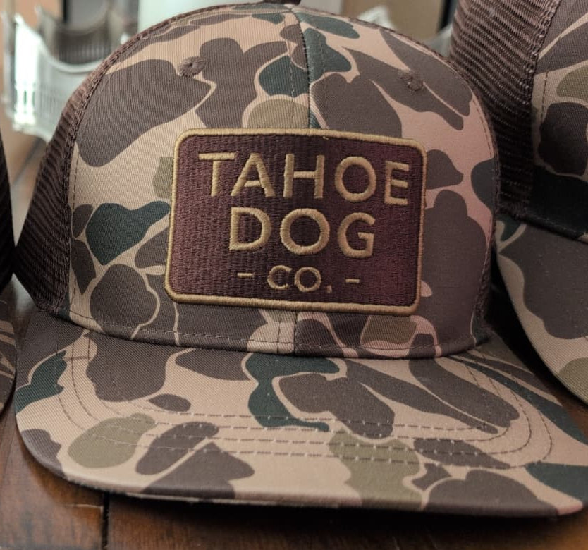 Camo trucker hat featuring Tahoe Dog Co. logo (aka "The Rex")
