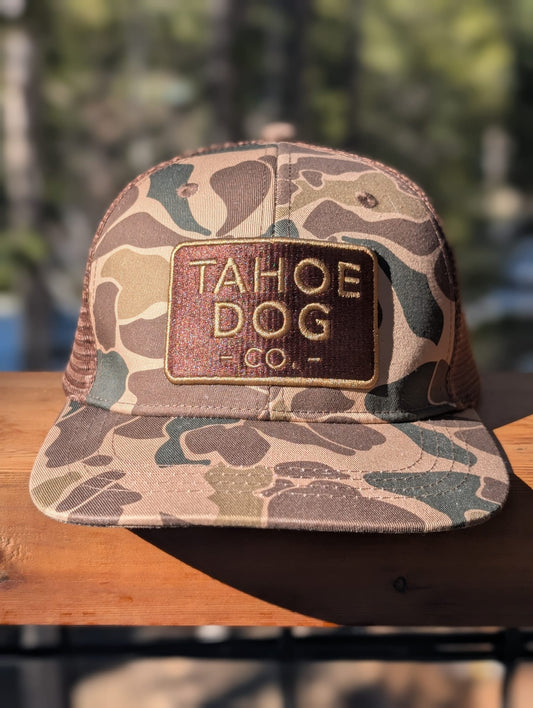Camo trucker hat featuring Tahoe Dog Co. logo (aka "The Rex")