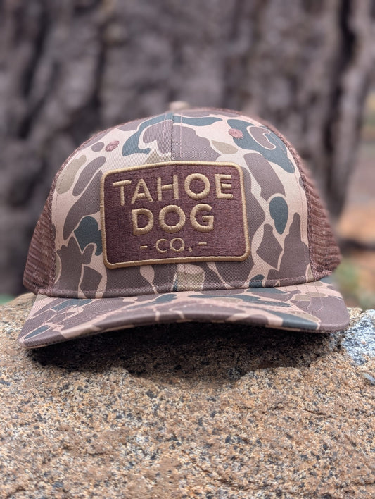 Camo trucker hat featuring Tahoe Dog Co. logo (aka "The Rex")
