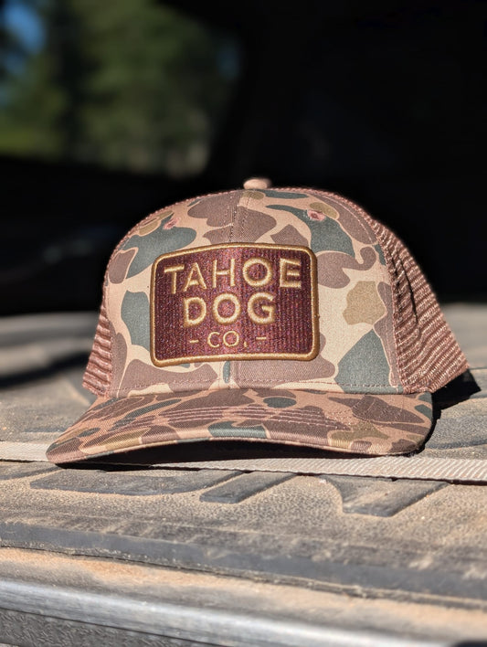 Camo trucker hat featuring Tahoe Dog Co. logo (aka "The Rex")
