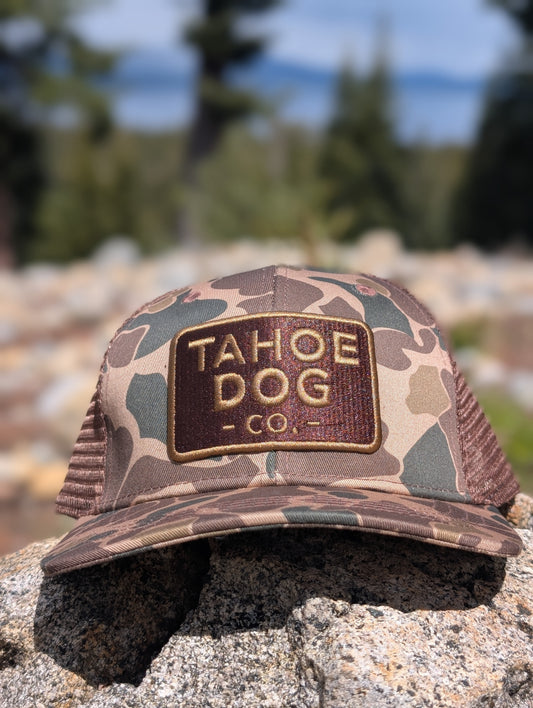 Camo trucker hat featuring Tahoe Dog Co. logo (aka "The Rex")